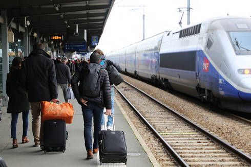 voyageurs de dos sur le quai d'une gare et TGV sur la voie