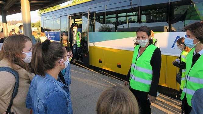 Christelle Morançais parle avec des écoliers devant un car Aléop