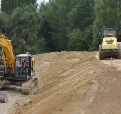 Sur un chantier, une pelle et un rouleau compresseur