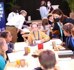 La Présidente de la Région Pays de la Loire, Christelle Morançais portant un masque, discute avec de jeunes attablés lors de la cérémonie des bénévoles au Vendée Globe